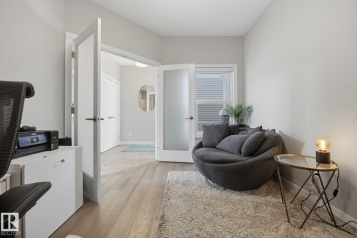 Interior space featuring wood-finish flooring, light grey wall paint, and white trim   GREAT DEN - 3870 Robins Crescent Nw, Edmonton, AB - Indoor Photo Showing Other Room