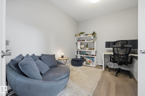 Neutral-toned room with light wood-finish flooring, a plush area rug, and white walls - 3870 Robins Crescent Nw, Edmonton, AB - Indoor