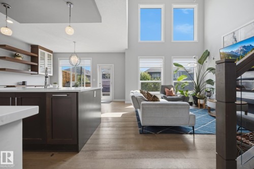 Open-concept living space featuring high ceilings, abundant natural light through multiple windows, and wood-finish flooring - 3870 Robins Crescent Nw, Edmonton, AB - Indoor