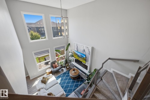 Two-story living area featuring a vaulted ceiling and four large windows - 3870 Robins Crescent Nw, Edmonton, AB - Indoor Photo Showing Other Room