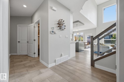 Foyer featuring wood-finish flooring, recessed lighting, and a modern staircase with dark wood newel posts and handrails - 3870 Robins Crescent Nw, Edmonton, AB - Indoor Photo Showing Other Room