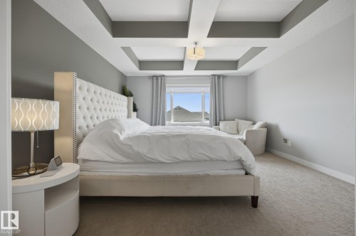 Recessed ceiling with layered trim, framed window with neutral curtains, and light-colored carpeting - 3870 Robins Crescent Nw, Edmonton, AB - Indoor Photo Showing Bedroom
