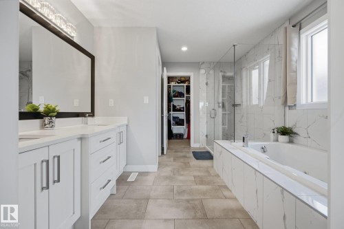 Spacious bathroom featuring a double vanity with white cabinetry and solid surface countertops - 3870 Robins Crescent Nw, Edmonton, AB - Indoor Photo Showing Bathroom