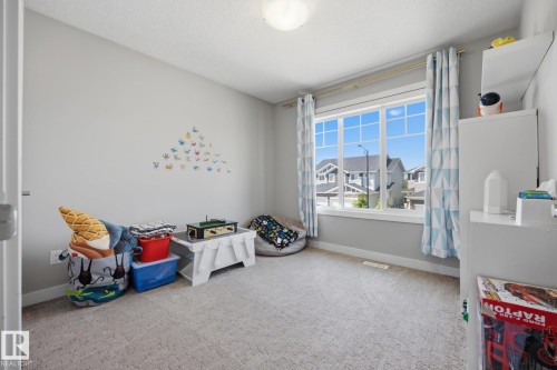 Room featuring neutral wall paint, light-colored carpet flooring, and a large multi-pane window with white trim - 3870 Robins Crescent Nw, Edmonton, AB - Indoor