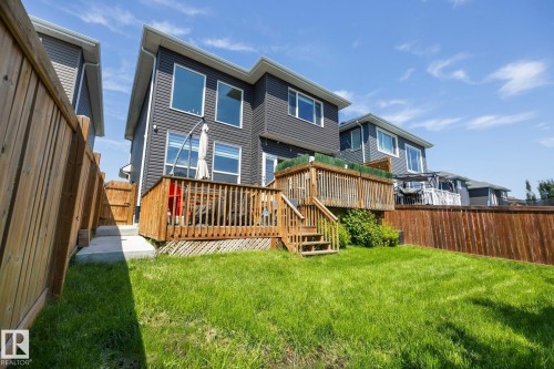 Expansive rear yard featuring a wooden deck with railing, stairs, and a spacious green lawn - 3870 Robins Crescent Nw, Edmonton, AB - Outdoor With Deck Patio Veranda