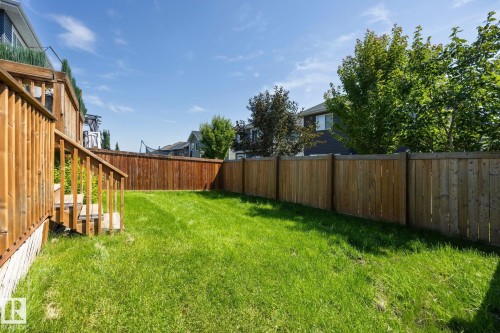 Expansive backyard featuring a manicured lawn, full wood fencing, and a multi-level wood deck with stairs - 3870 Robins Crescent Nw, Edmonton, AB - Outdoor With Backyard