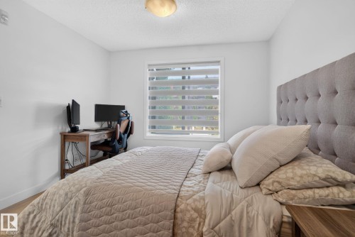 Neutral color palette with wood-finish flooring - #203 5521 7 Av Sw, Edmonton, AB - Indoor Photo Showing Bedroom