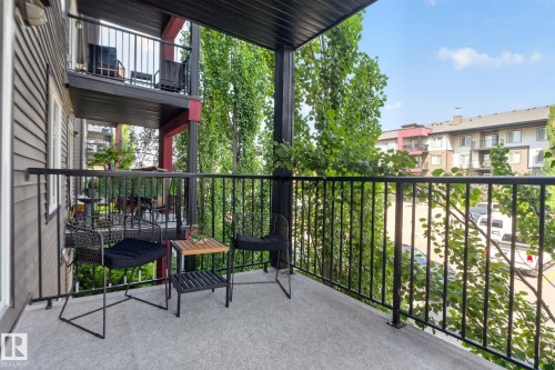 Private balcony featuring a textured concrete surface and sturdy black metal railings - #203 5521 7 Av Sw, Edmonton, AB - Outdoor With Balcony With Exterior