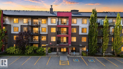 Multi-story residential building featuring a distinct red accent facade - #203 5521 7 Av Sw, Edmonton, AB - Outdoor With Balcony With Facade