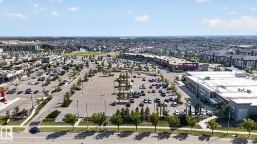 Retail development featuring multiple commercial buildings with extensive surface parking and surrounding residential areas - #203 5521 7 Av Sw, Edmonton, AB - Outdoor With View