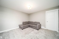 Carpeted room featuring light gray walls, white trim, and a five-panel interior door - 