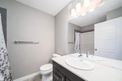 Bathroom featuring a dark wood-finish vanity with a white countertop, an oval undermount sink, and a chrome faucet - 