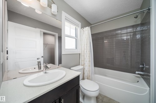 Bathroom featuring a white vanity with an oval sink, a light-colored countertop, and a large mirror - 114 James Crescent, St. Albert, AB - Indoor Photo Showing Bathroom