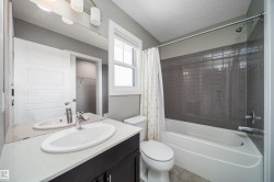 Bathroom featuring a white vanity with an oval sink, a light-colored countertop, and a large mirror - 