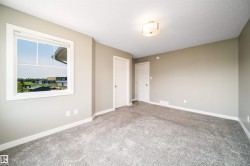 Neutral-toned interior room featuring light gray walls, plush gray carpeting, and white trim - 