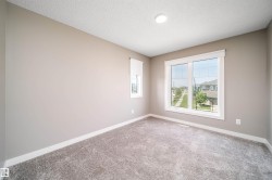Carpeted room featuring neutral-toned walls, white trim, and a large window with white framing - 