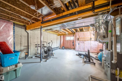 Unfinished basement with concrete walls, exposed ceiling joists, and a painted concrete floor - 114 James Crescent, St. Albert, AB - Indoor Photo Showing Basement