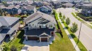 Contemporary two-story residence featuring a multi-gable roofline, a two-car garage with dark wood-finish doors, and a red entry door - 114 James Crescent, St. Albert, AB  - Outdoor With Facade 