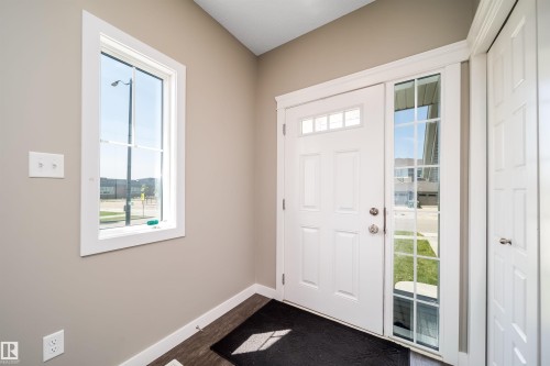 Entryway featuring a white paneled door with transom windows, a grid-patterned sidelight, and a vertical window with white trim - 114 James Crescent, St. Albert, AB - Indoor Photo Showing Other Room