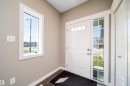 Entryway featuring a white paneled door with transom windows, a grid-patterned sidelight, and a vertical window with white trim - 114 James Crescent, St. Albert, AB  - Indoor Photo Showing Other Room 