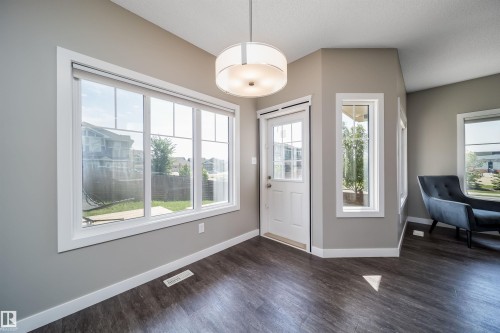 Spacious interior featuring wood-finish flooring, light gray walls, and white trim - 114 James Crescent, St. Albert, AB - Indoor Photo Showing Other Room