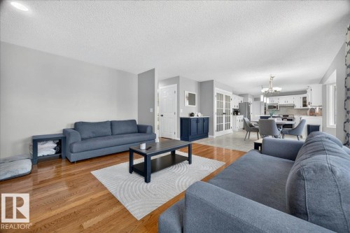 Open-concept living space featuring wood-finish flooring, light grey wall tones, and recessed lighting - #47 21061 Wye Rd, Rural Strathcona County, AB - Indoor Photo Showing Living Room