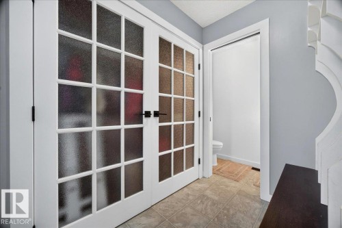 Double French doors featuring frosted glass panels and matte black hardware - #47 21061 Wye Rd, Rural Strathcona County, AB - Indoor Photo Showing Other Room