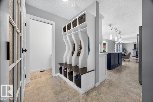 Entryway with built-in storage bench featuring individual cubbies and overhead shelving - #47 21061 Wye Rd, Rural Strathcona County, AB - Indoor Photo Showing Other Room