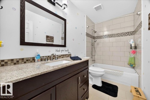 Bathroom featuring a dark wood vanity with a granite countertop and an undermount sink - #47 21061 Wye Rd, Rural Strathcona County, AB - Indoor Photo Showing Bathroom