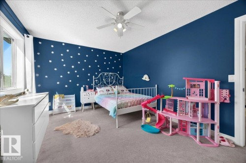 Carpeted interior room with a sloped ceiling and a white ceiling fan with integrated lighting - #47 21061 Wye Rd, Rural Strathcona County, AB - Indoor Photo Showing Bedroom