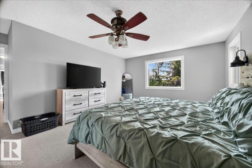 Carpeted bedroom with a window, ceiling fan with integrated lighting, and light gray painted walls - #47 21061 Wye Rd, Rural Strathcona County, AB - Indoor Photo Showing Bedroom