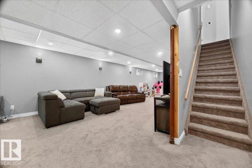 Spacious lower-level area featuring light gray walls, recessed lighting, and soft carpet flooring - #47 21061 Wye Rd, Rural Strathcona County, AB - Indoor