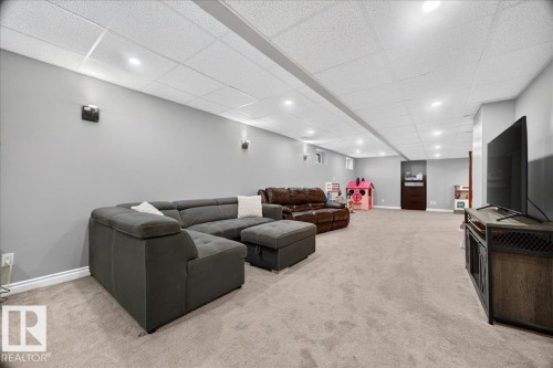 Spacious lower-level room featuring light gray wall paint, recessed lighting, and a neutral-toned carpet - #47 21061 Wye Rd, Rural Strathcona County, AB - Indoor