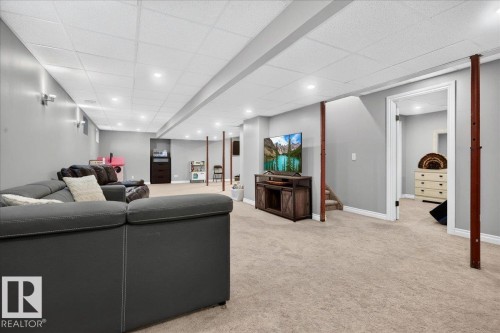 Expansive carpeted area featuring recessed lighting, light gray walls, white trim, and exposed wood support beams - #47 21061 Wye Rd, Rural Strathcona County, AB - Indoor
