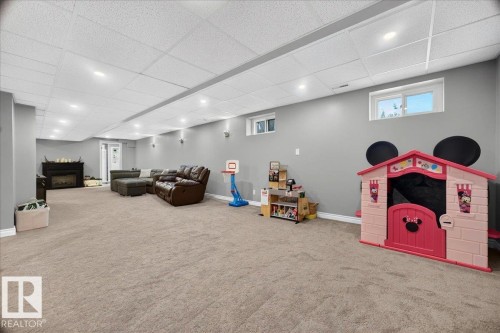Spacious finished basement featuring light gray walls and plush carpeting throughout - #47 21061 Wye Rd, Rural Strathcona County, AB - Indoor Photo Showing Basement