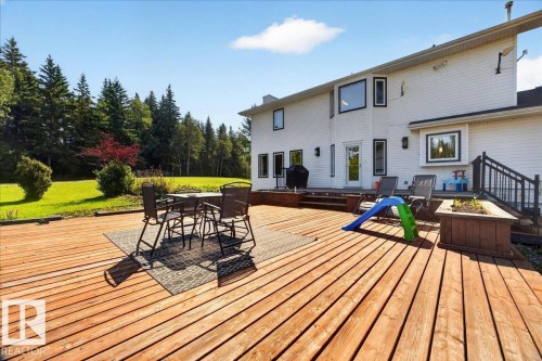 Expansive rear deck featuring natural wood planks, a built-in planter box, and black metal railings - #47 21061 Wye Rd, Rural Strathcona County, AB - Outdoor With Deck Patio Veranda With Exterior