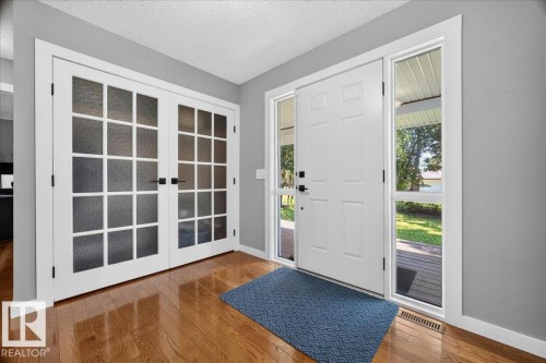 Front entry with rich wood-finish flooring, a white paneled door, and sidelight windows - #47 21061 Wye Rd, Rural Strathcona County, AB - Indoor Photo Showing Other Room