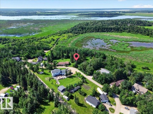 Aerial perspective showcasing a residential community surrounded by extensive green spaces and bodies of water - #47 21061 Wye Rd, Rural Strathcona County, AB - Outdoor With View