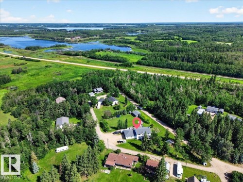Expansive property featuring a two-story residence with light-colored siding and a dark roof, surrounded by mature trees - #47 21061 Wye Rd, Rural Strathcona County, AB - Outdoor With View
