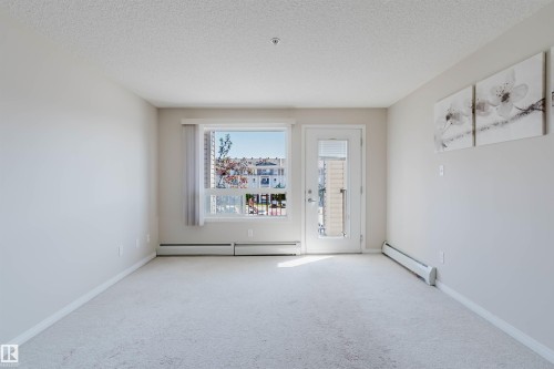Bright interior space featuring light-colored carpeting, white baseboards, and neutral wall tones - #7306 7327 South Terwillegar Dr Nw, Edmonton, AB - Indoor Photo Showing Other Room