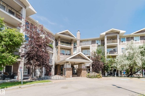 Multi-story building featuring balconies with metal railings, stone veneer accents, and a covered entry - #7306 7327 South Terwillegar Dr Nw, Edmonton, AB - Outdoor With Balcony With Facade
