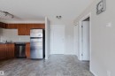 Kitchen area featuring wood-finish cabinetry, stainless steel refrigerator, and stainless steel dishwasher - #7306 7327 South Terwillegar Dr Nw, Edmonton, AB  - Indoor Photo Showing Kitchen With Double Sink 