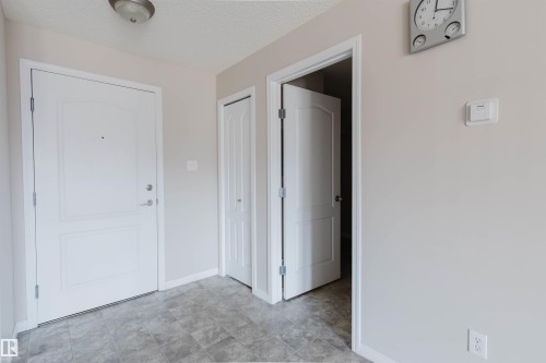 Entryway featuring a white paneled door, gray tiled flooring, a built-in closet, and an interior doorway with a white paneled door - #7306 7327 South Terwillegar Dr Nw, Edmonton, AB - Indoor Photo Showing Other Room