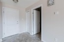 Entryway featuring a white paneled door, gray tiled flooring, a built-in closet, and an interior doorway with a white paneled door - #7306 7327 South Terwillegar Dr Nw, Edmonton, AB  - Indoor Photo Showing Other Room 