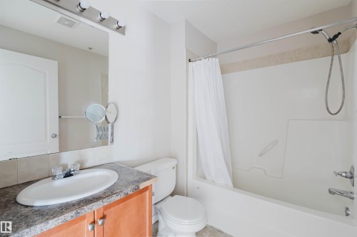 Bathroom featuring a shower-tub combination, a vanity with a laminate countertop, and a white porcelain toilet - #7306 7327 South Terwillegar Dr Nw, Edmonton, AB - Indoor Photo Showing Bathroom