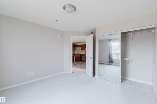 Bedroom featuring neutral wall paint, light-toned carpeting, and a ceiling-mounted light fixture - #7306 7327 South Terwillegar Dr Nw, Edmonton, AB - Indoor Photo Showing Other Room