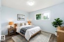 Bright room featuring wood-finish flooring, a contemporary window, and a flush-mount ceiling light fixture - 13524 62 Street Nw, Edmonton, AB  - Indoor Photo Showing Bedroom 