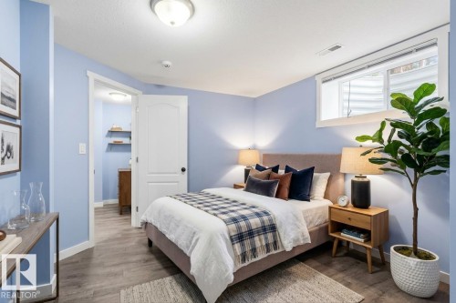 Inviting bedroom featuring wood-finish flooring and a neutral color palette - 13524 62 Street Nw, Edmonton, AB - Indoor Photo Showing Bedroom