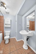 Bathroom featuring a pedestal sink, white toilet, and ceramic tile flooring - 