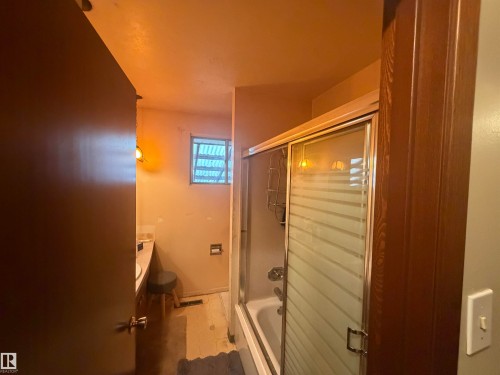 Tub-shower combination featuring a sliding glass door with horizontal frosted bands - 13207 117 Street, Edmonton, AB 